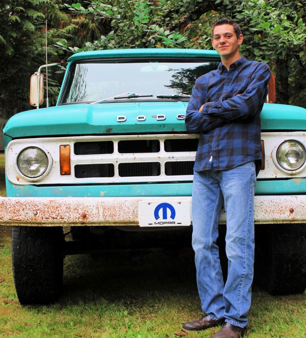 Kody standing in front of his blue Dodge truck