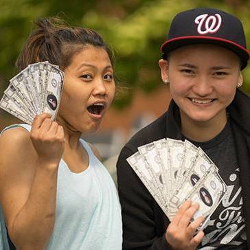 Two students holding cash like fans 