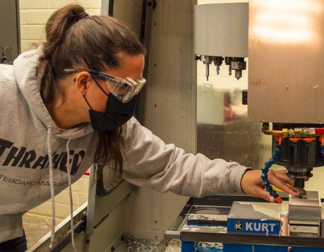 An RTC student operating a machining device