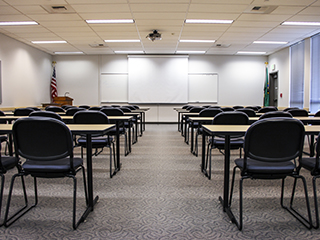 A large classroom seating 60 as seen from the back of the room.