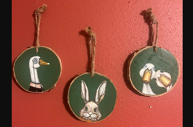 There round wood pieces wtih a duck, goose, and bird