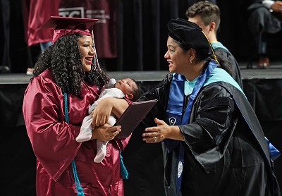 RTC student at graduation holding a baby 